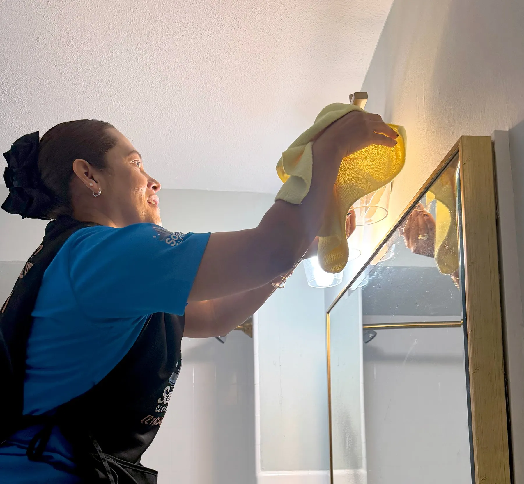 Solutions Cleaning team member dusting a staircase railing during a recurring house cleaning